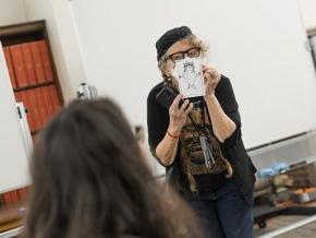 Lynda Barry holds up a drawing