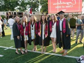 六名身着毕业礼服的学生站在操场上，上面写着“祝贺2024届毕业生”。