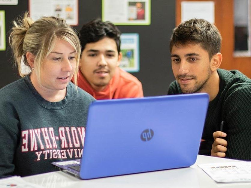 Students looking over an assignment on a computer
